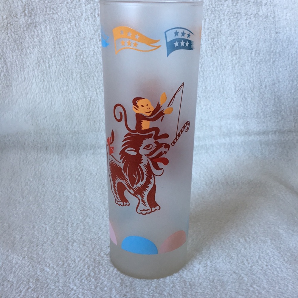 Tall drinking glass w/ monkey and tiger design.